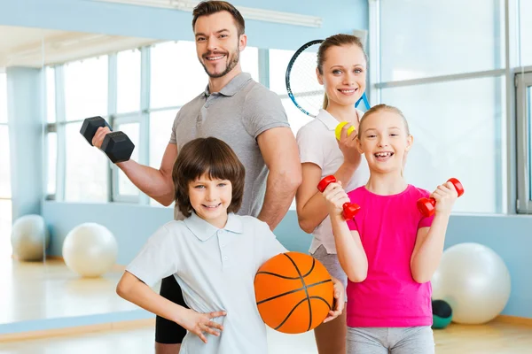 Família segurando diferentes equipamentos esportivos — Fotografia de Stock