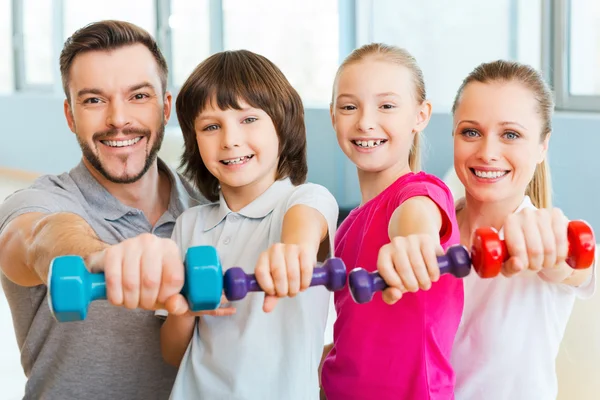 Happy family holding sports equipment — Stock Photo, Image