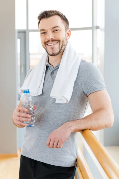 Człowiek z ręcznikiem trzymając butelkę z wodą — Zdjęcie stockowe