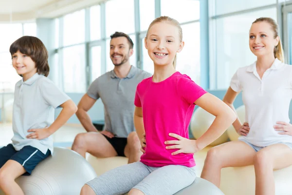 Niña haciendo ejercicio con su familia —  Fotos de Stock