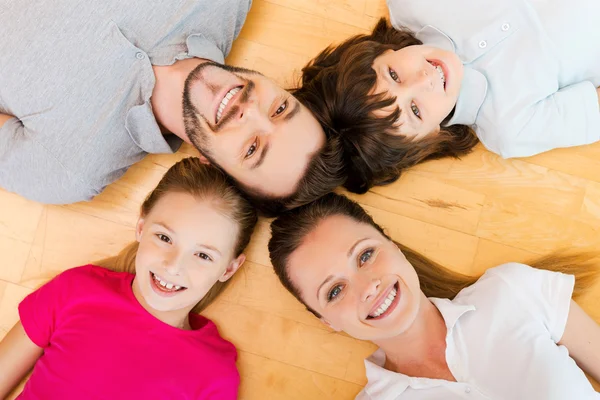 Счастливая семья лежит на полу — стоковое фото