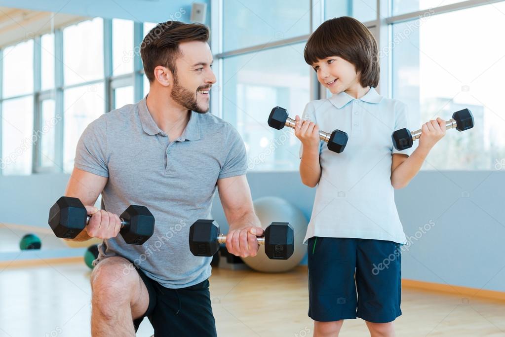 Father and son exercising with dumbbells