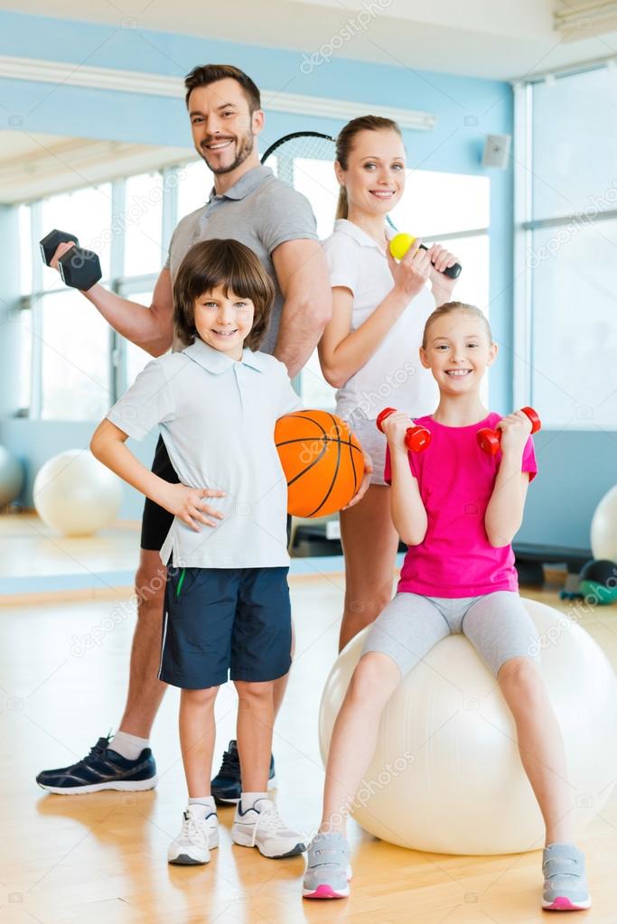 Family holding different sports equipment