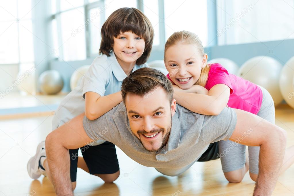 Children and father doing push-ups