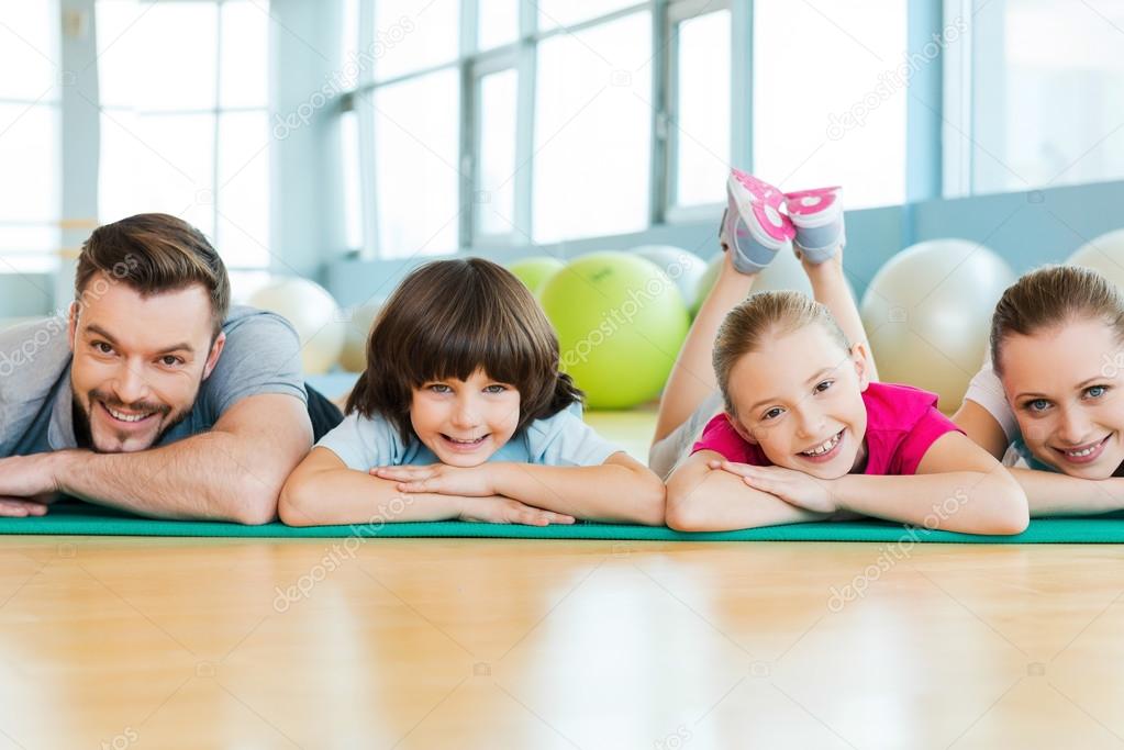 Happy family lying on exercise mat