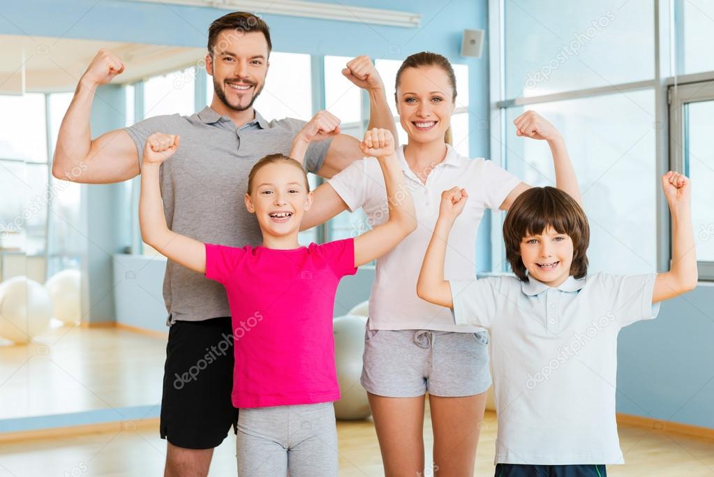 Happy sporty family showing their biceps