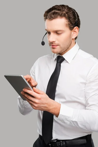 Hombre con auriculares trabajando en tableta digital — Foto de Stock