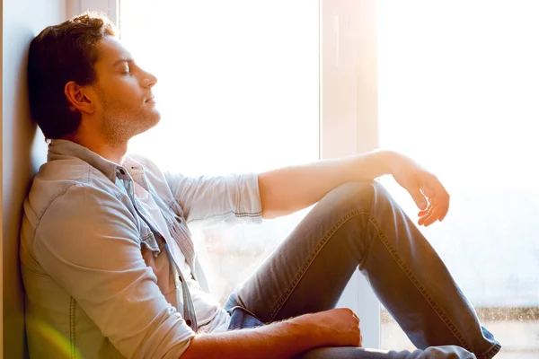 Man sitting at the windowsill — Stock Photo, Image