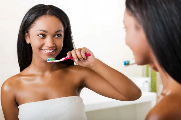 Mujer africana cepillándose los dientes — Foto de Stock