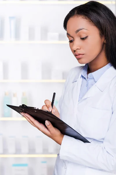 Frau im Laborkittel macht sich Notizen — Stockfoto