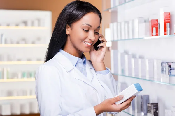 Woman talking on  phone in drugstore — Stock Photo, Image