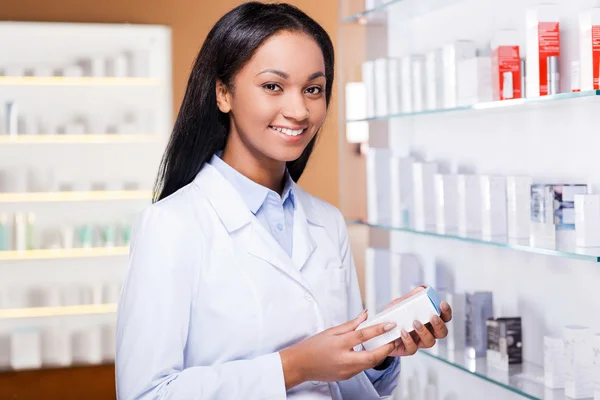 Afrikaanse vrouw in laboratoriumjas in drogisterij — Stockfoto