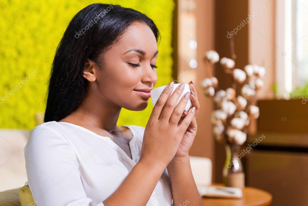 Woman holding coffee cup near nose