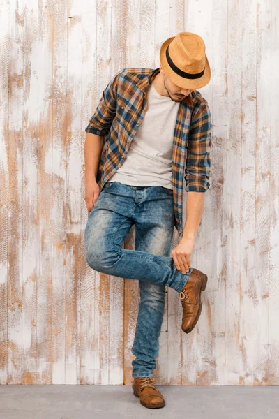 Bonito jovem homem ajustando jeans — Fotografia de Stock