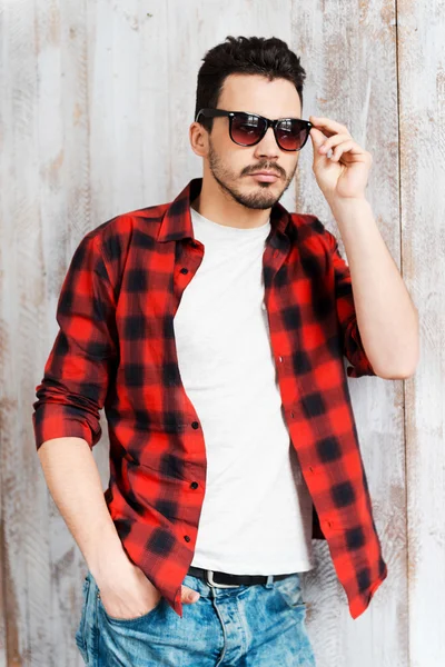 Hombre joven ajustando gafas de sol —  Fotos de Stock