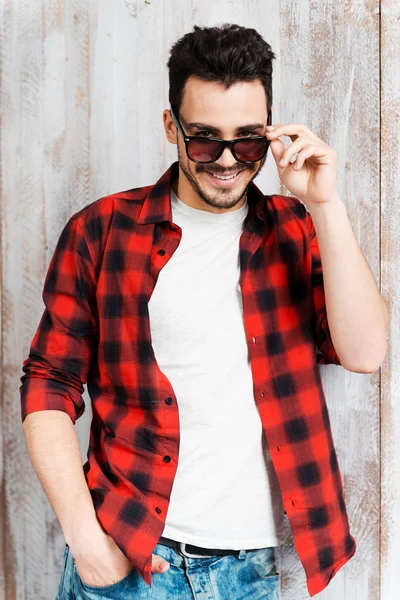 Joven ajustando sus gafas de sol — Foto de Stock