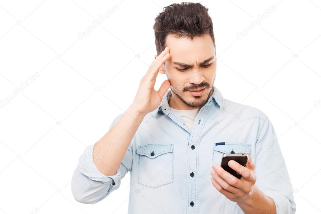 Frustrated man holding mobile phone — Stock Photo © gstockstudio 69639665