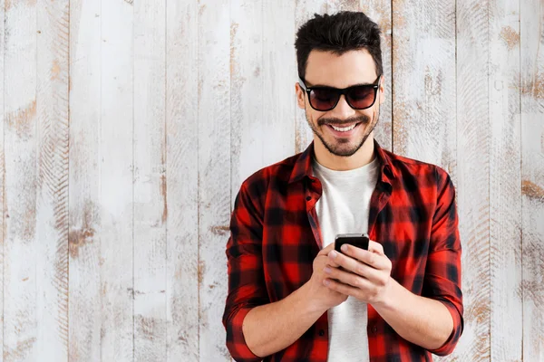 Joven sosteniendo teléfono móvil — Foto de Stock