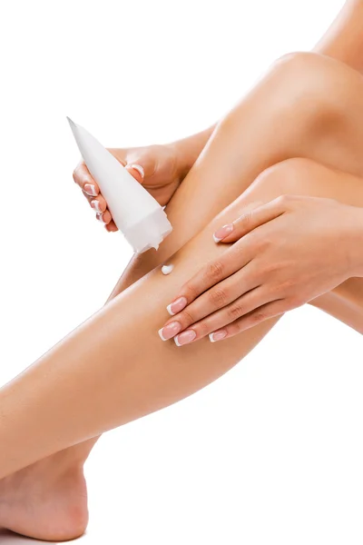 Woman applying body lotion on her legs — Stock Photo, Image