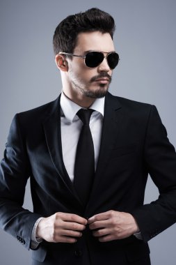 Adam kadar ceketinin düğmelerini güneş gözlüğü