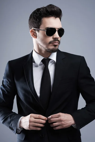 Man in sunglasses buttoning his jacket — Stock Photo, Image