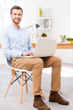 Dizüstü bilgisayarda office çalışma tişörtlü adam