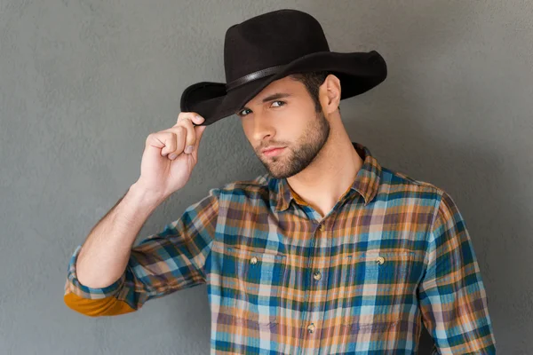 Homem ajustando seu chapéu de cowboy — Fotografia de Stock