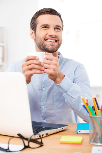 Uomo che tiene una tazza di caffè sul posto di lavoro — Foto Stock