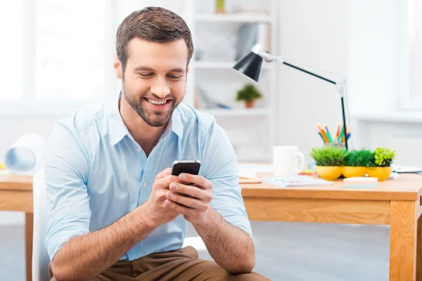 Man holding mobile phone at working place — Stock Photo, Image