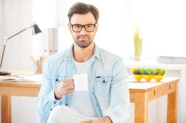 Kahve tutan tişörtlü adam