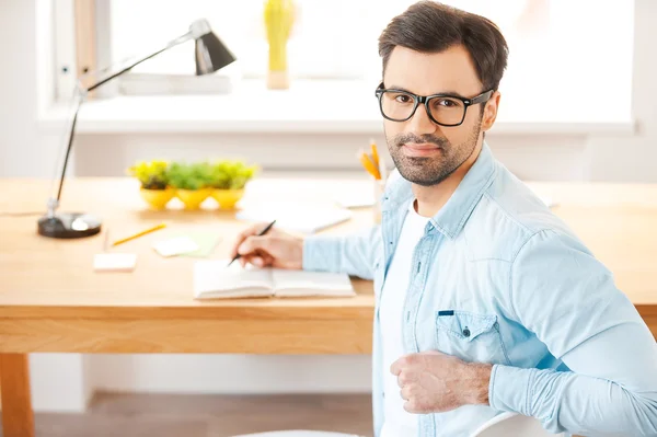 Man in het shirt en brillen schrijven in Opmerking pad — Stockfoto