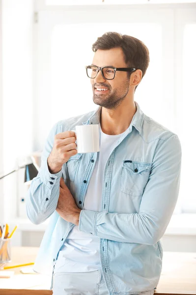 Человек в очках держит чашку кофе — стоковое фото