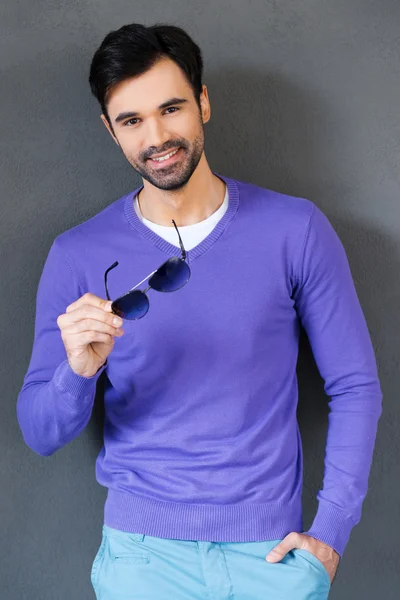 Young man holding eyewear and smiling — Stock Photo, Image