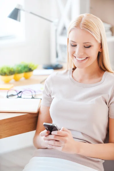 Žena držící mobilní telefon v kanceláři — Stock fotografie