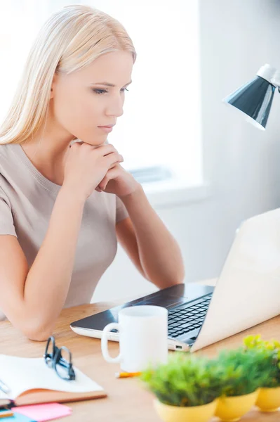 Frau schaut im Büro auf Laptop — Stockfoto