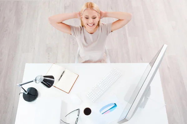 Smiling woman sitting at her working place — Stock Photo, Image