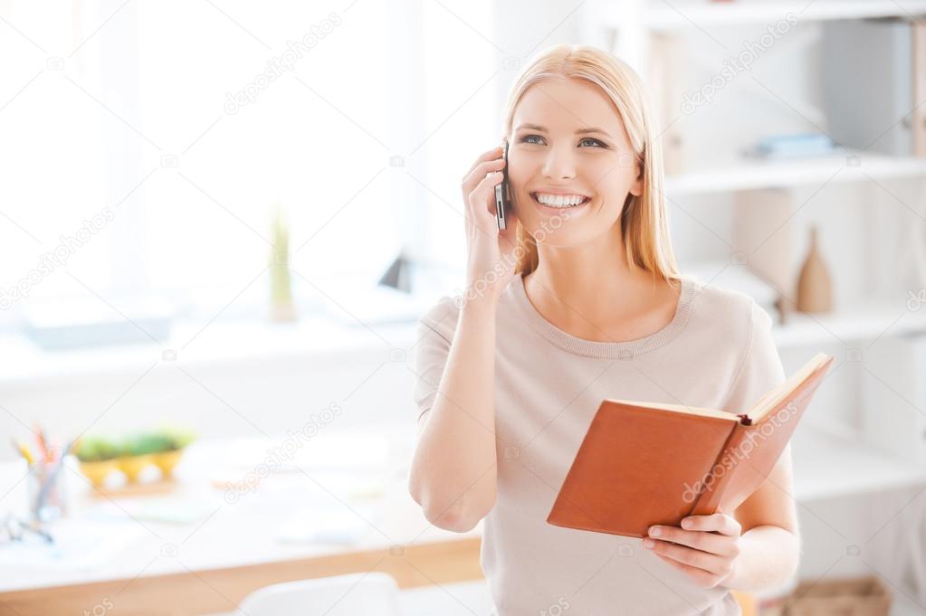 Woman talking on mobile phone in office