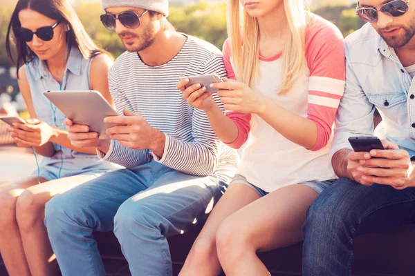 Young people looking at their gadgets — Stock Photo, Image