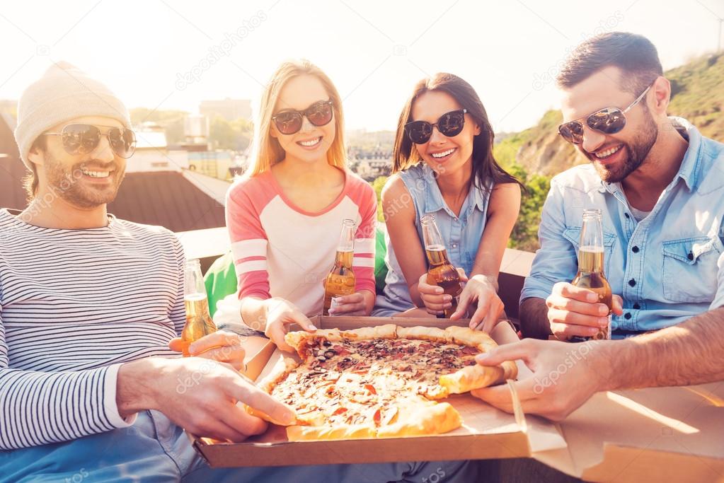 People eating pizza and drinking beer
