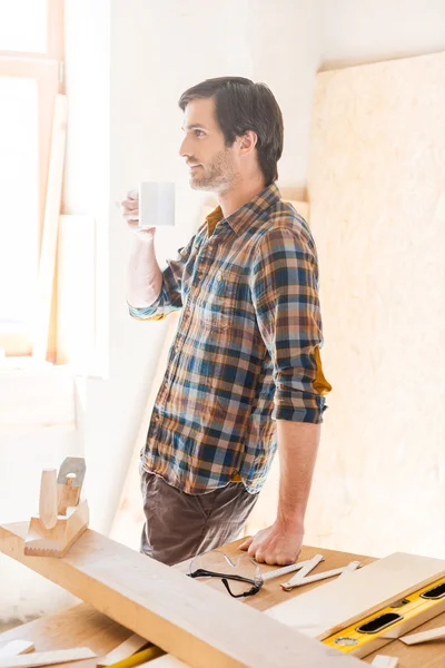 Thoughtful carpenter holding coffee cup — Stock Photo, Image