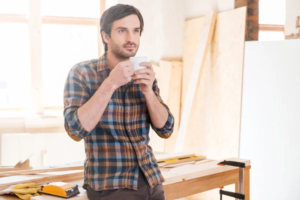 Thoughtful carpenter holding coffee cup — Stock Photo, Image