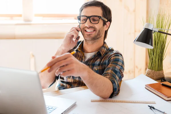 Man talking on phone and pointing at laptop — Stock Photo, Image