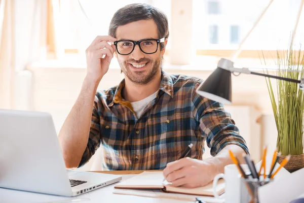 Man adjusting  eyewear at working place — Stock Photo, Image