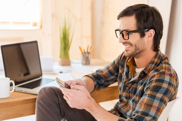 Homme tenant un téléphone portable sur le lieu de travail — Photo