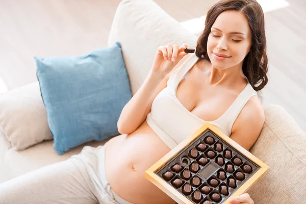 Беременная женщина ест шоколад — стоковое фото
