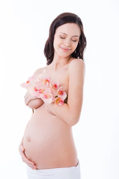 Pregnant woman covering breast by flower Stock Picture