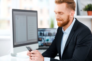 Sakallı işadamı cep telefonu tutan