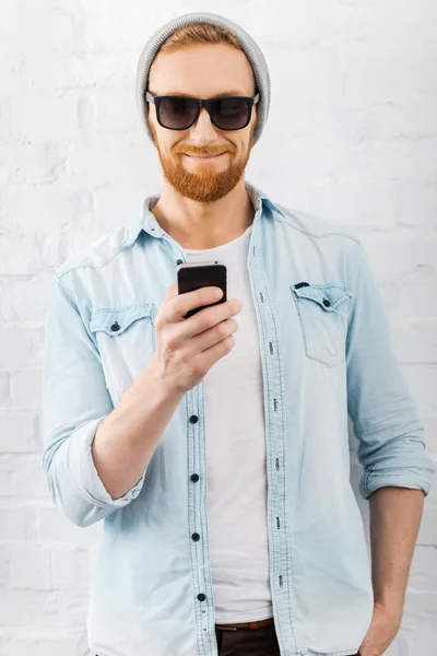 Uomo barbuto in possesso di telefono cellulare — Foto Stock