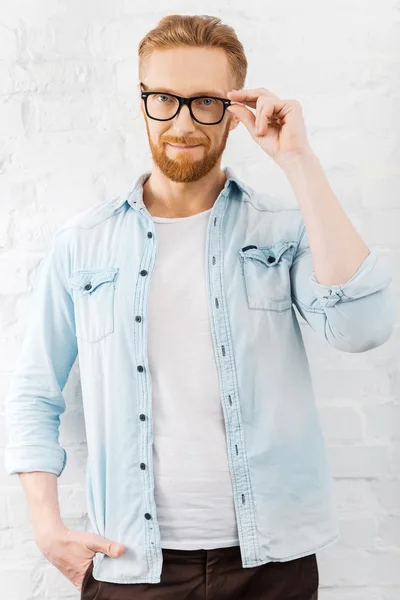 Hombre barbudo ajustando sus gafas —  Fotos de Stock