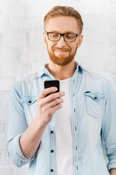 Uomo barbuto in possesso di telefono cellulare — Foto Stock